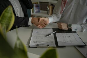 deux personnes se serrant la main sur un morceau de papier