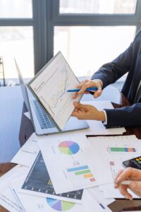 Des professionnels du monde des affaires discutent de graphiques et de tableaux financiers dans un bureau.