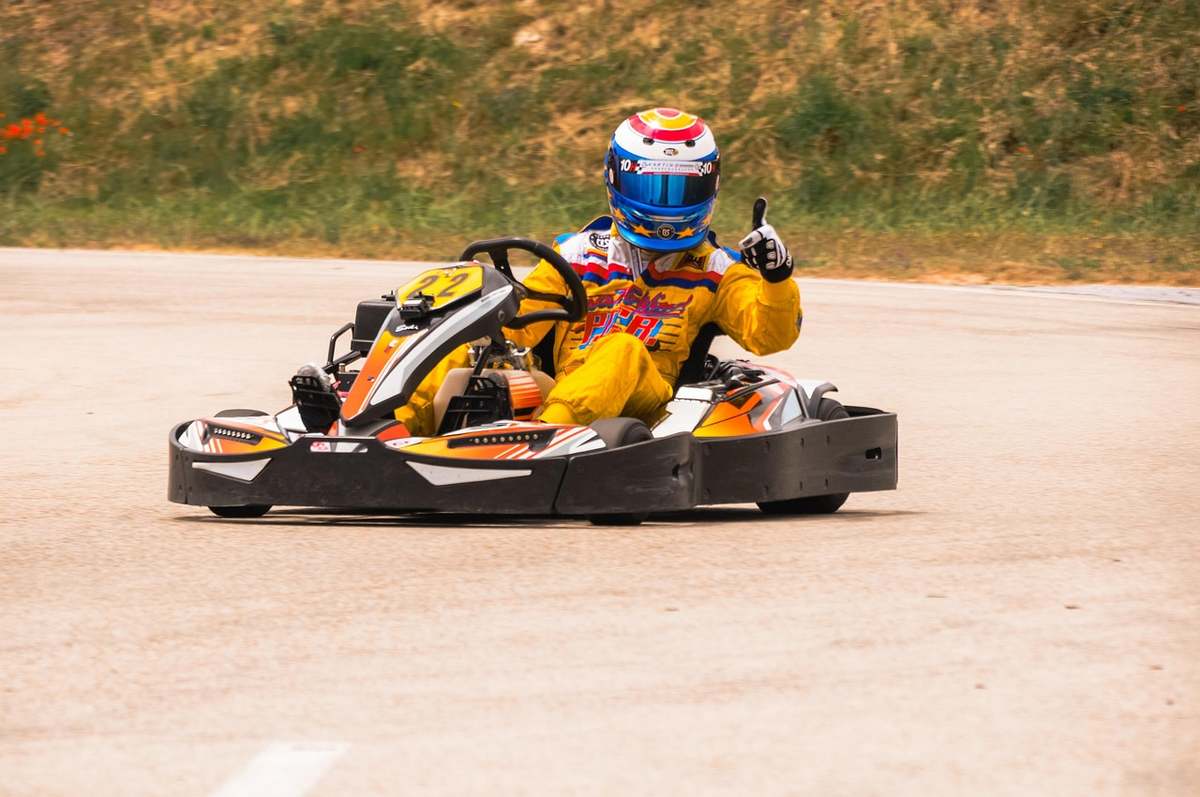 Deux karts de course sur une piste avec des pilotes en combinaison jaune et casque