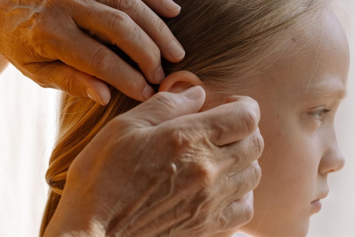Professionnel ajustant un appareil auditif contour d'oreille derrière l'oreille d'une patiente