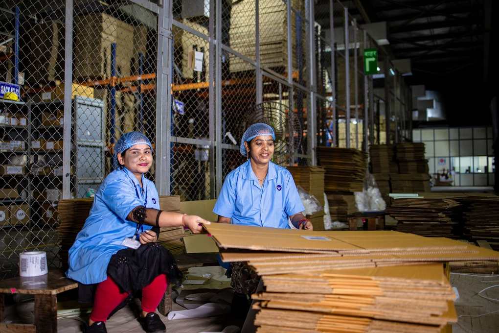Femmes en bleu triant des cartons dans un entrepôt