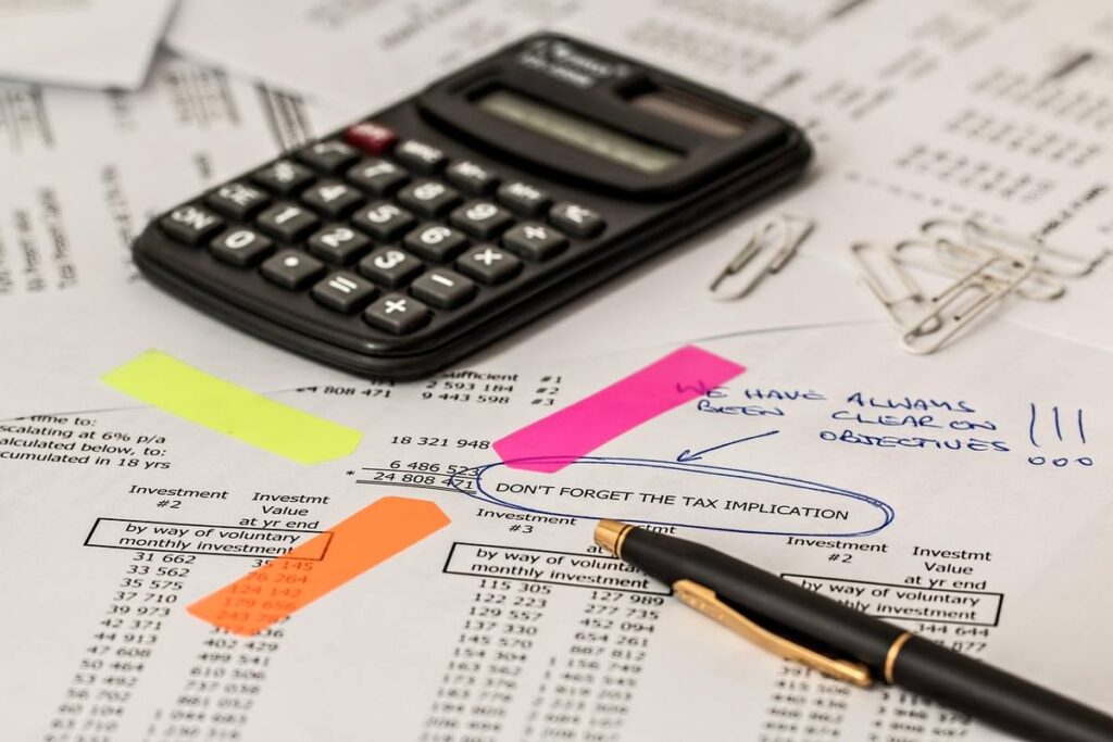 Calculatrice, stylo et feuilles de papier avec post-it