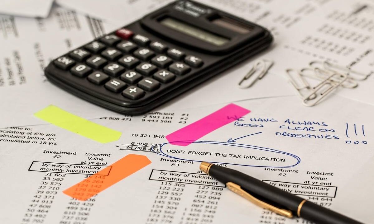 Calculatrice, stylo et feuilles de papier avec post-it