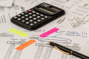 Calculatrice, stylo et feuilles de papier avec post-it